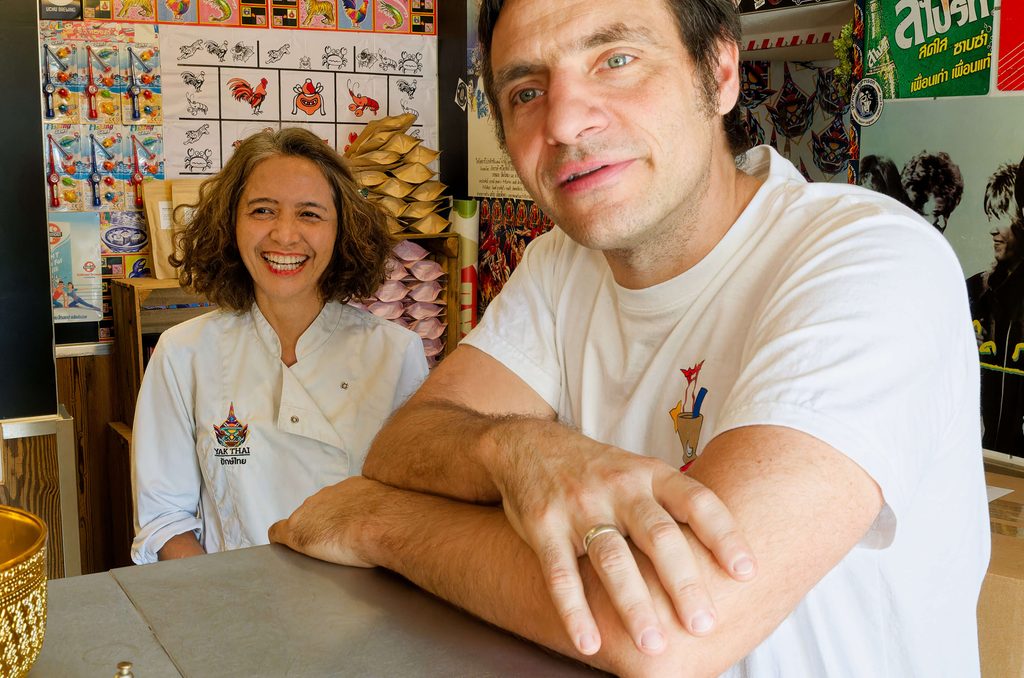 Chonticha und Alex vor den bunt dekorierten Wänden ihrer Streetfoodbar 
